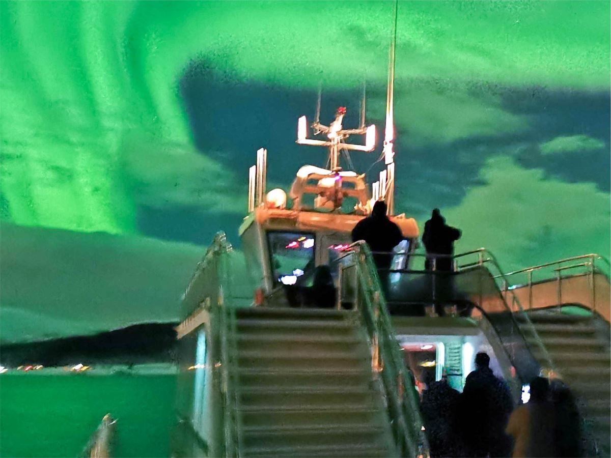 Gjester ser på nordlyset fra toppen av båten