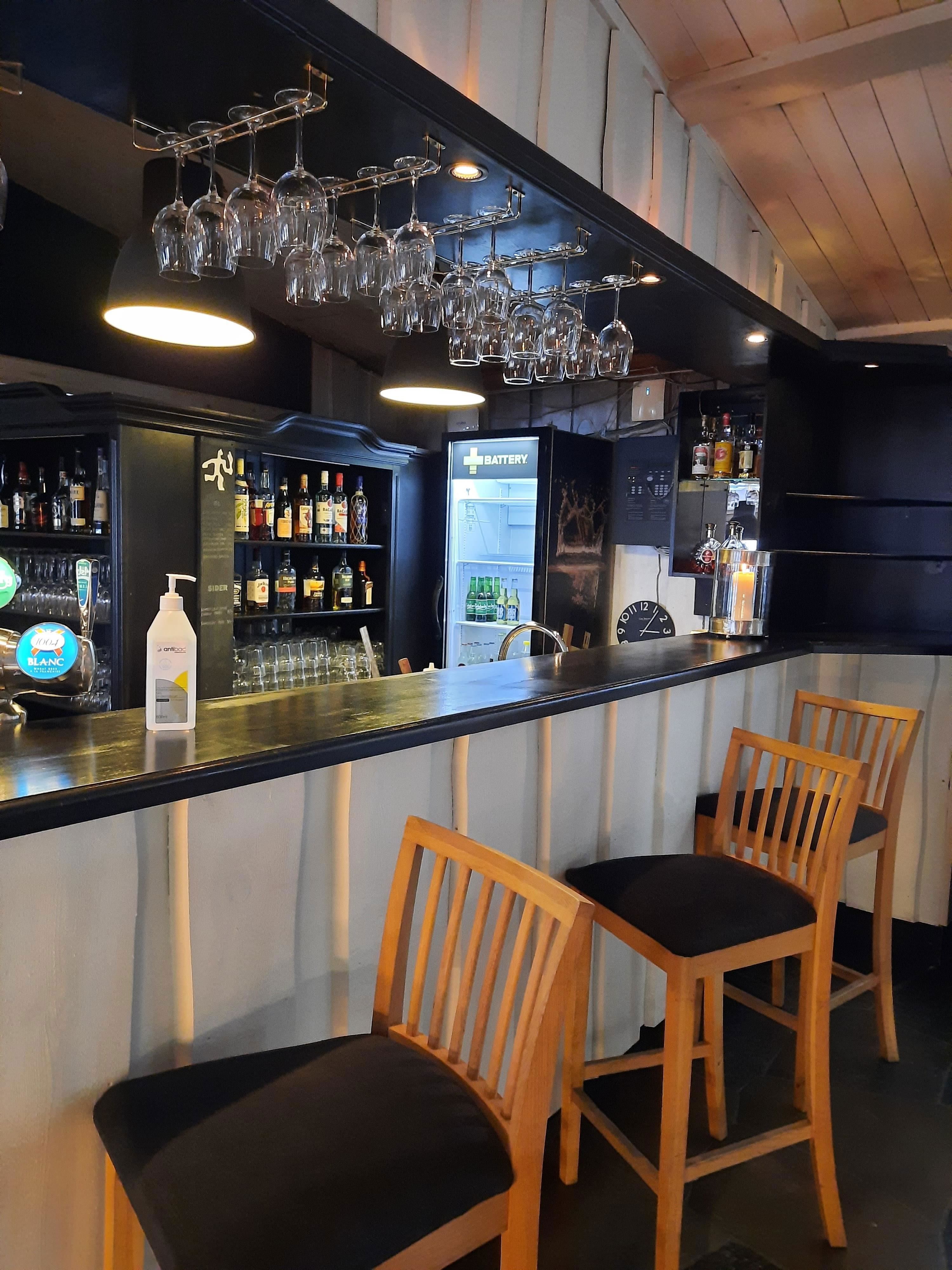 A bar with wine glasses from the ceiling.