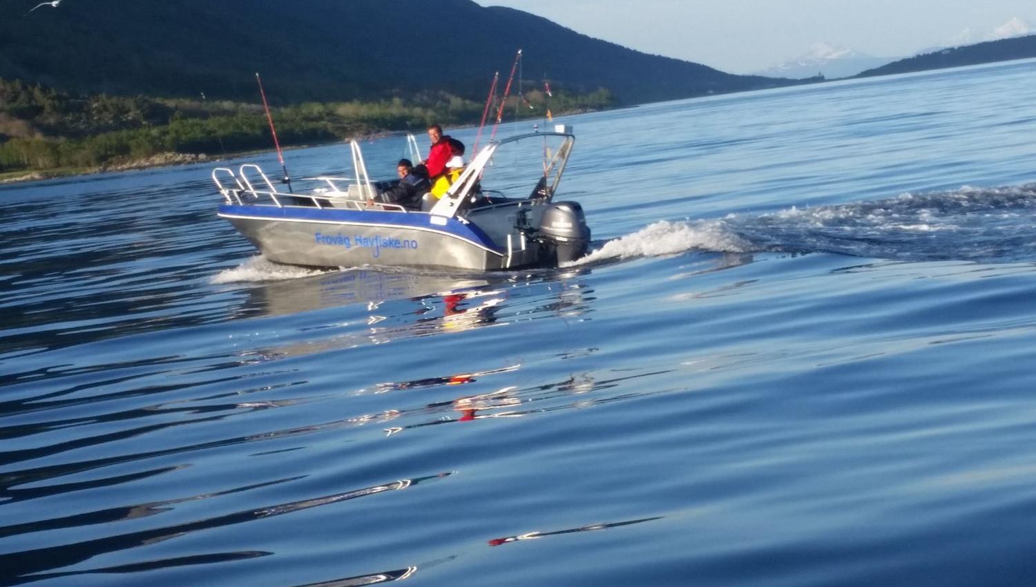 to personer drar ut på fjorden i båt