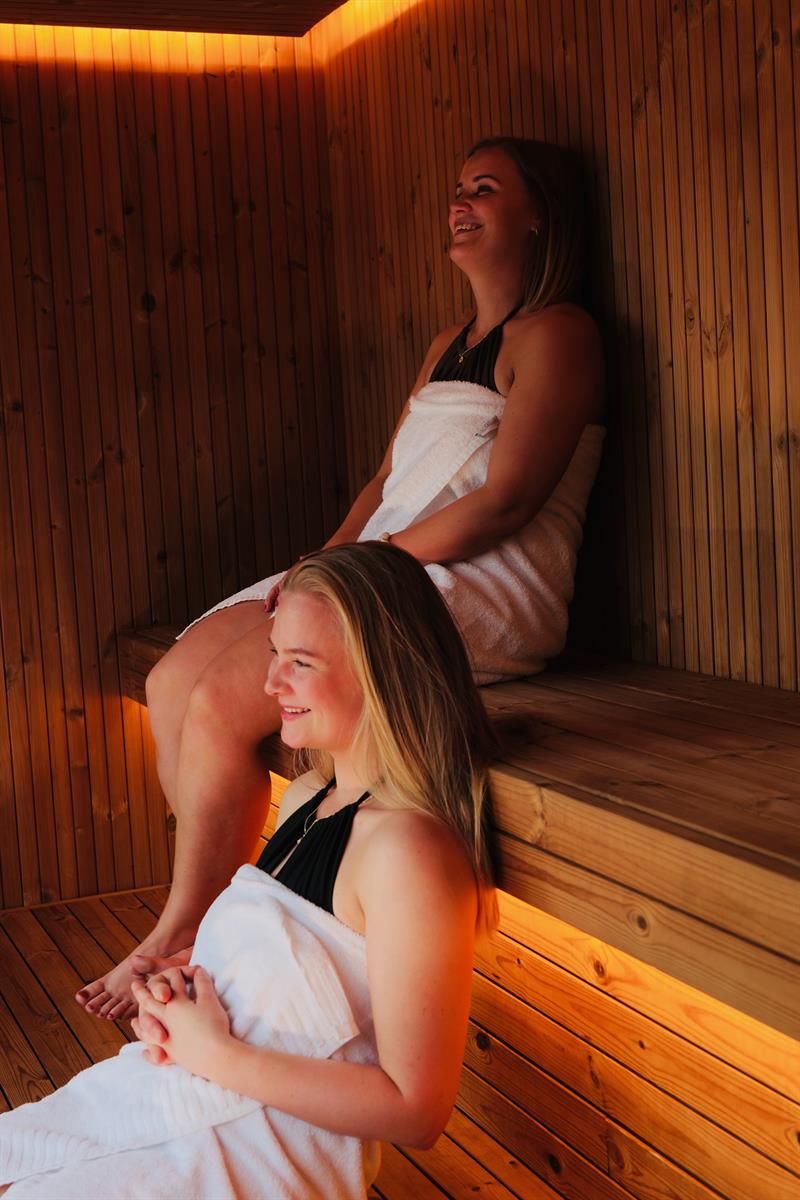 Two guests relaxing in the sauna at Tyssedal Hotel.