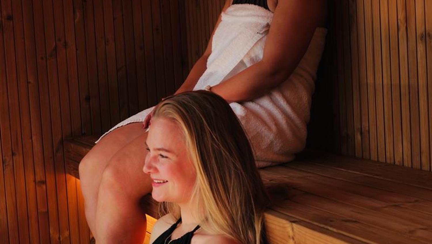 Two guests relaxing in the sauna at Tyssedal Hotel.