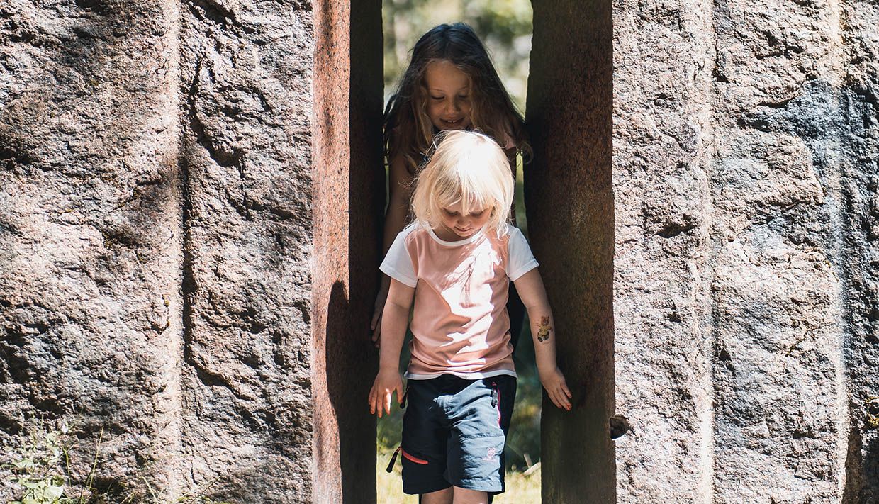 Children exploring the stone portal in Steinparken Rosendal – a fun stop for families.