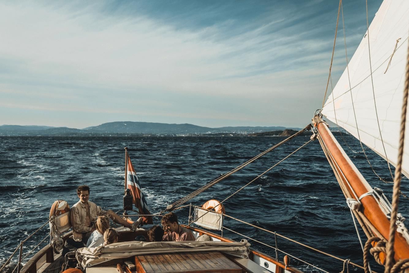 Family in sailing boat, blue ocean and sky