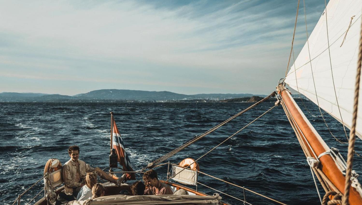 Family in sailing boat, blue ocean and sky
