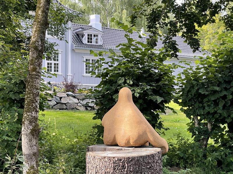 Art at a tree with an house in the background
