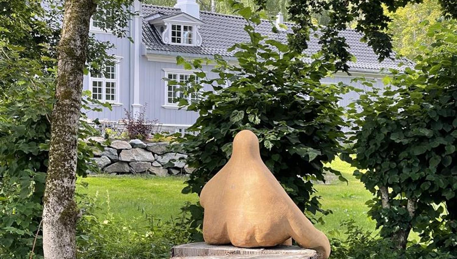Art at a tree with an house in the background