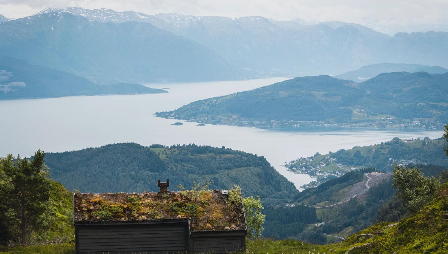 View over fjord and cultural landscape in Hardanger, Norway, with traditional mountain cabin