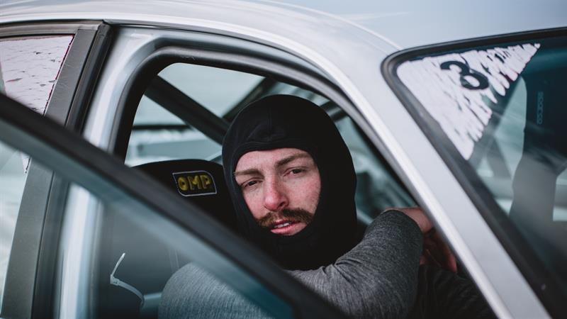 A driver is sitting in the car after an extreme rally experience.