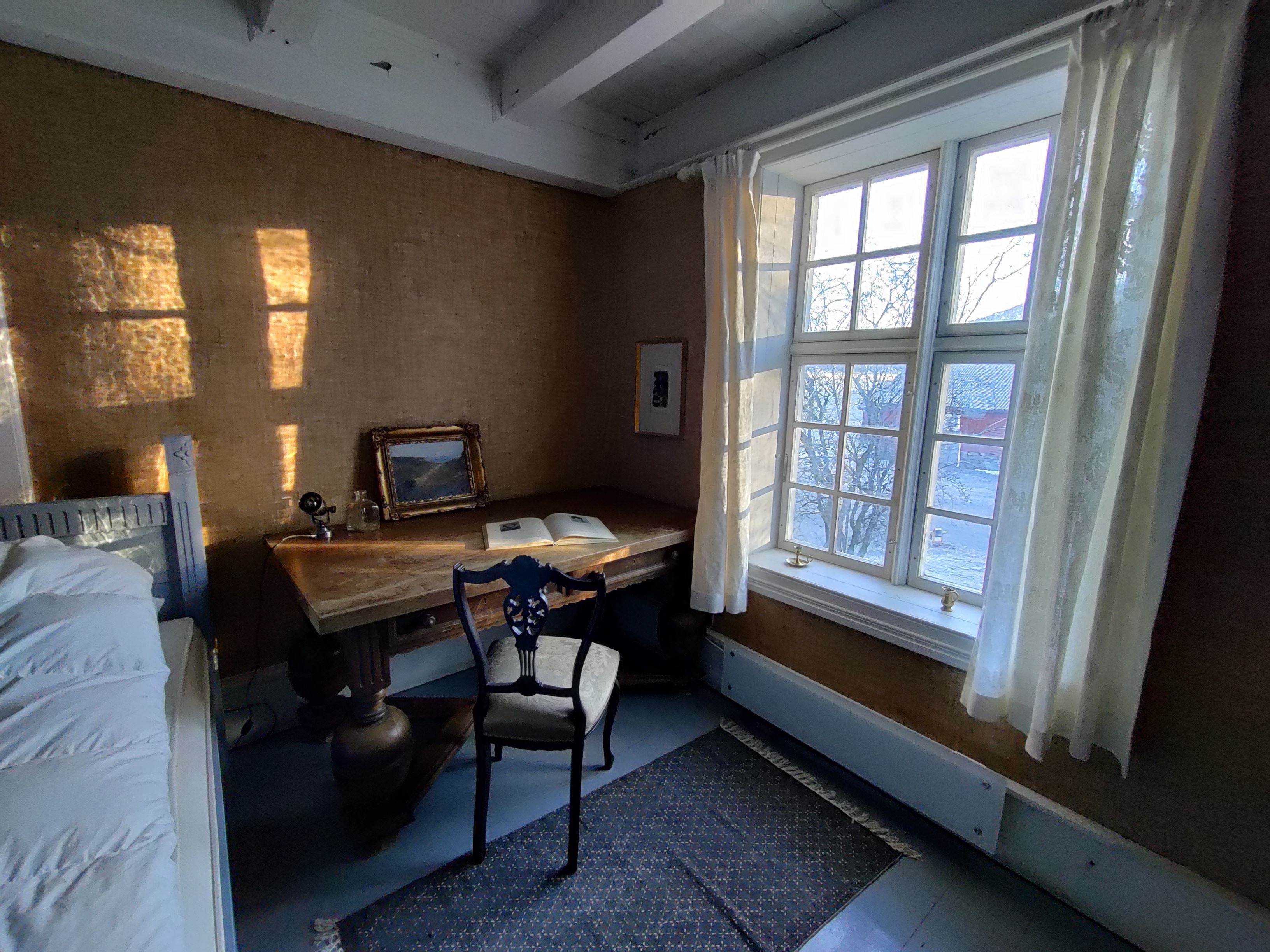 Salon and dining area at Skrivergaarden with classic furniture and large windows overlooking the garden.