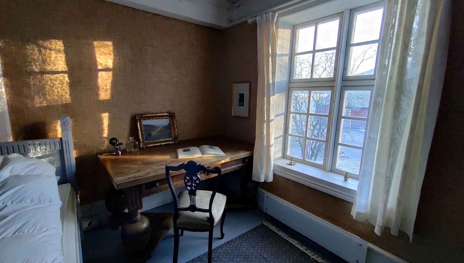 Salon and dining area at Skrivergaarden with classic furniture and large windows overlooking the garden.