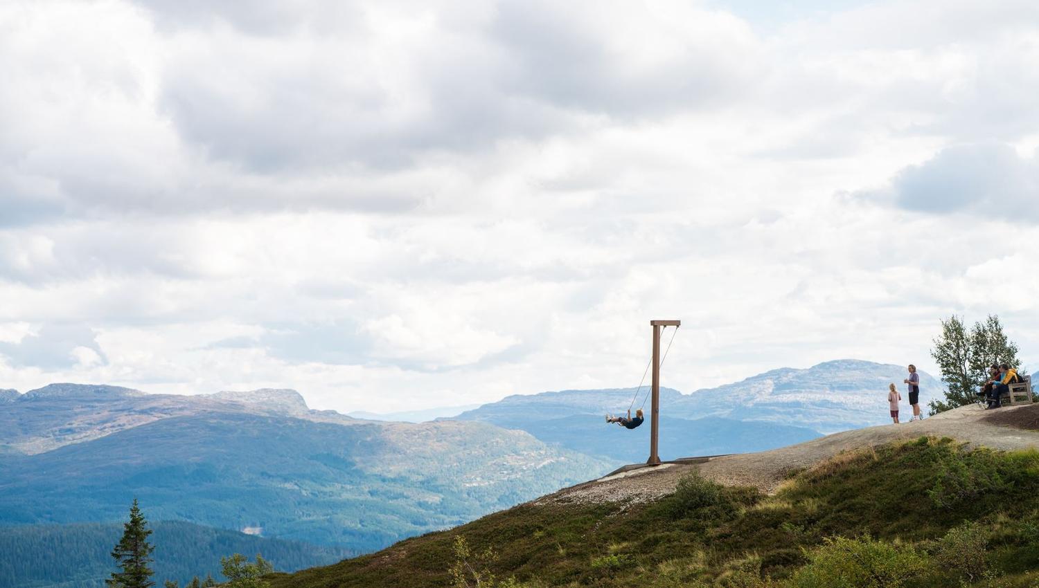 En gutt husker på hangurshusko, sett fra siden. I bakgrunnen ser du fjellene.