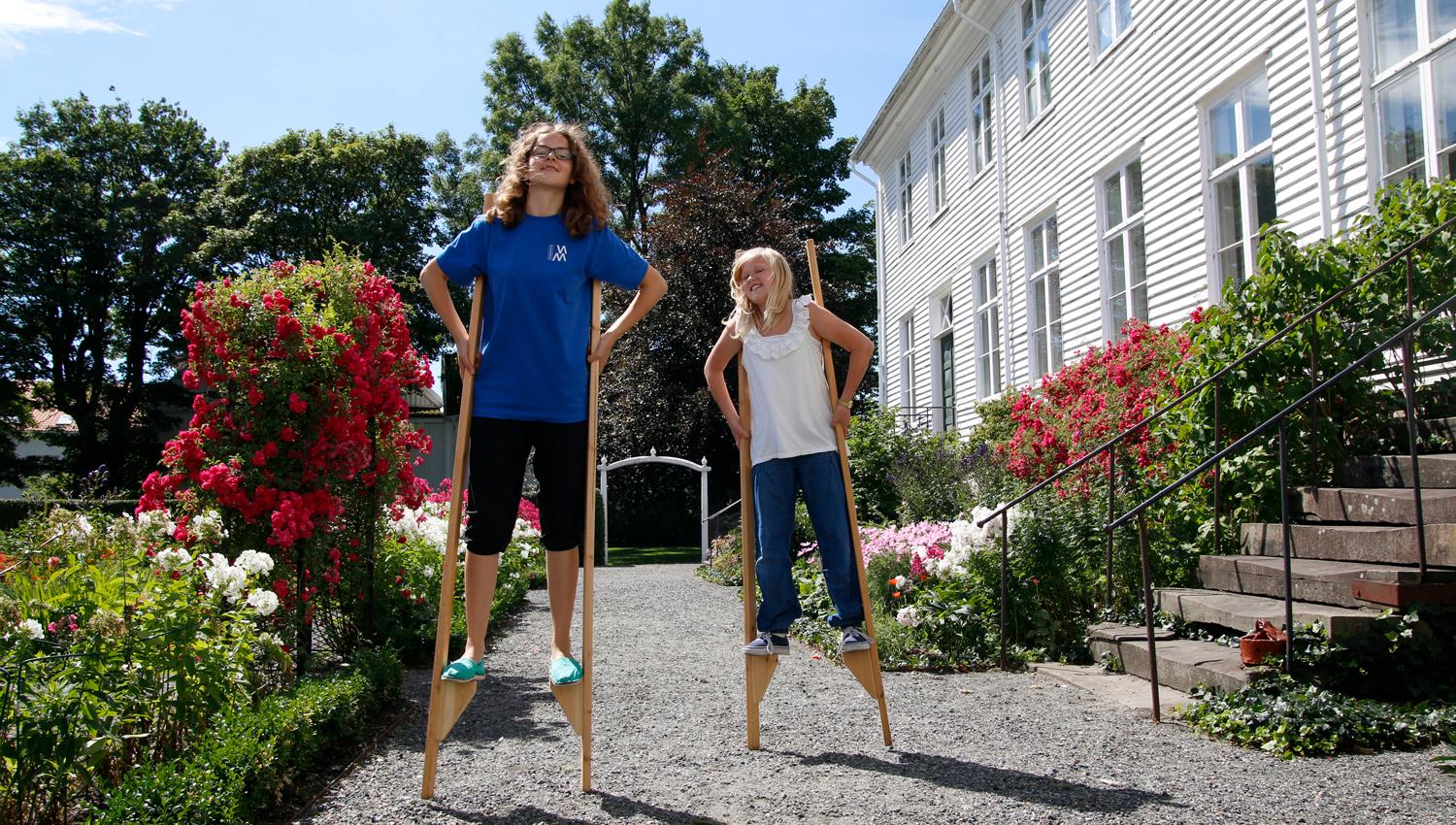 Two people walking on stilts at Andorsen Farm.