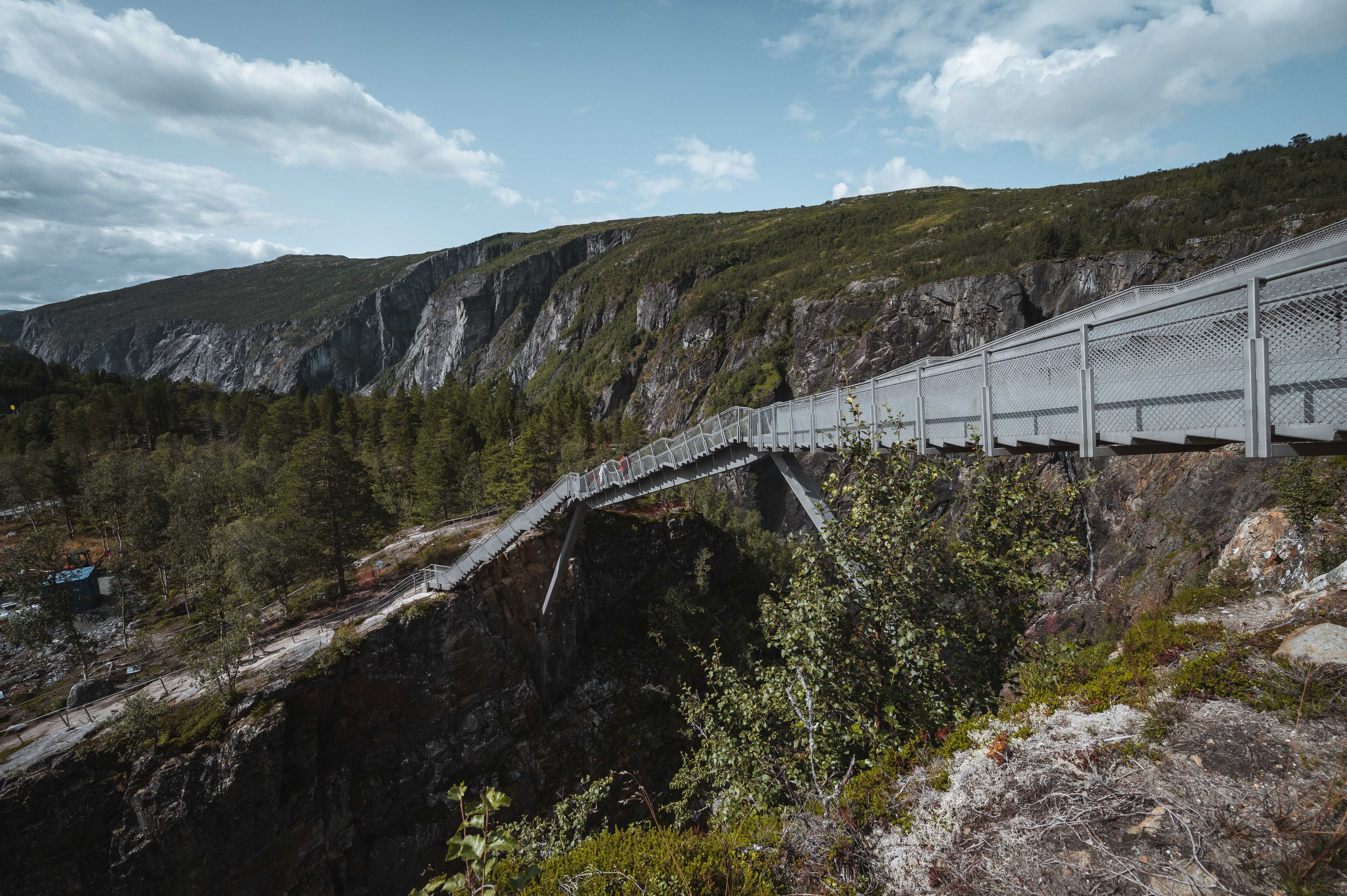Pedestrian bridge crossing the canyon near Vøringsfossen, surrounded by mountains.