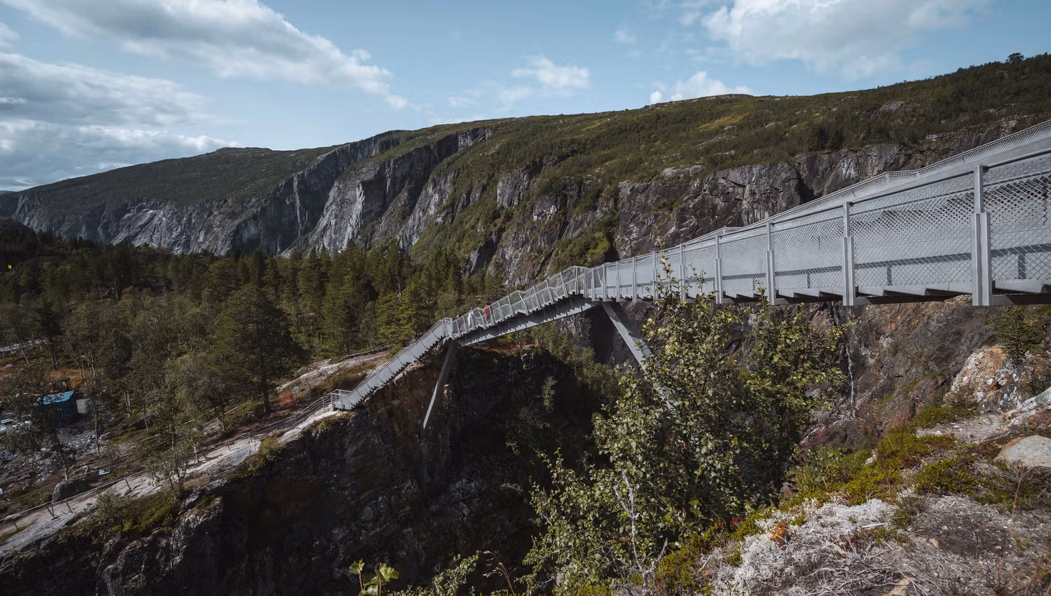 Pedestrian bridge crossing the canyon near Vøringsfossen, surrounded by mountains.