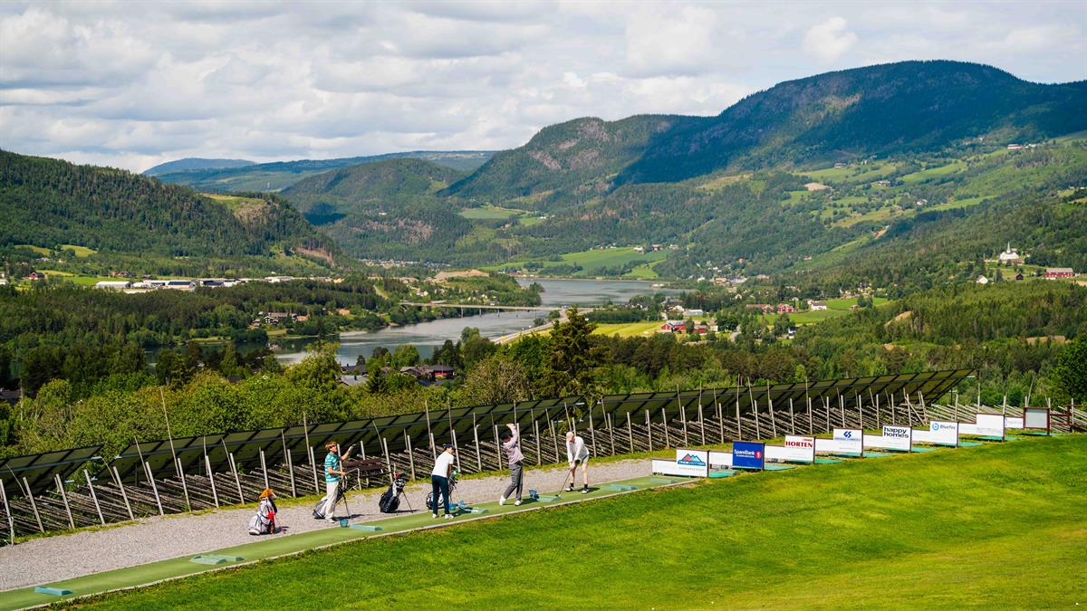 Golf course overlooking a valley and mountains.