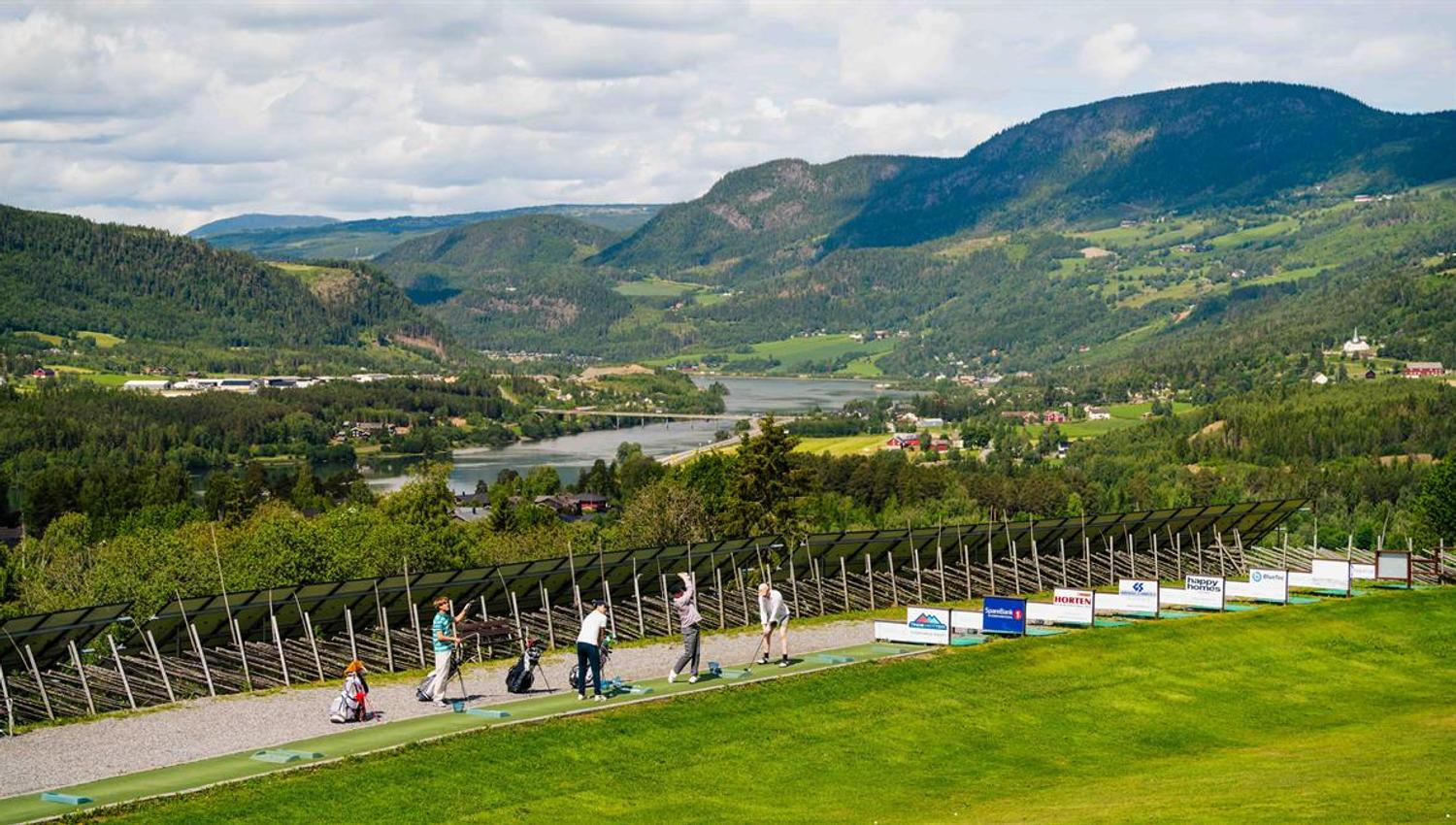 Golf course overlooking a valley and mountains.