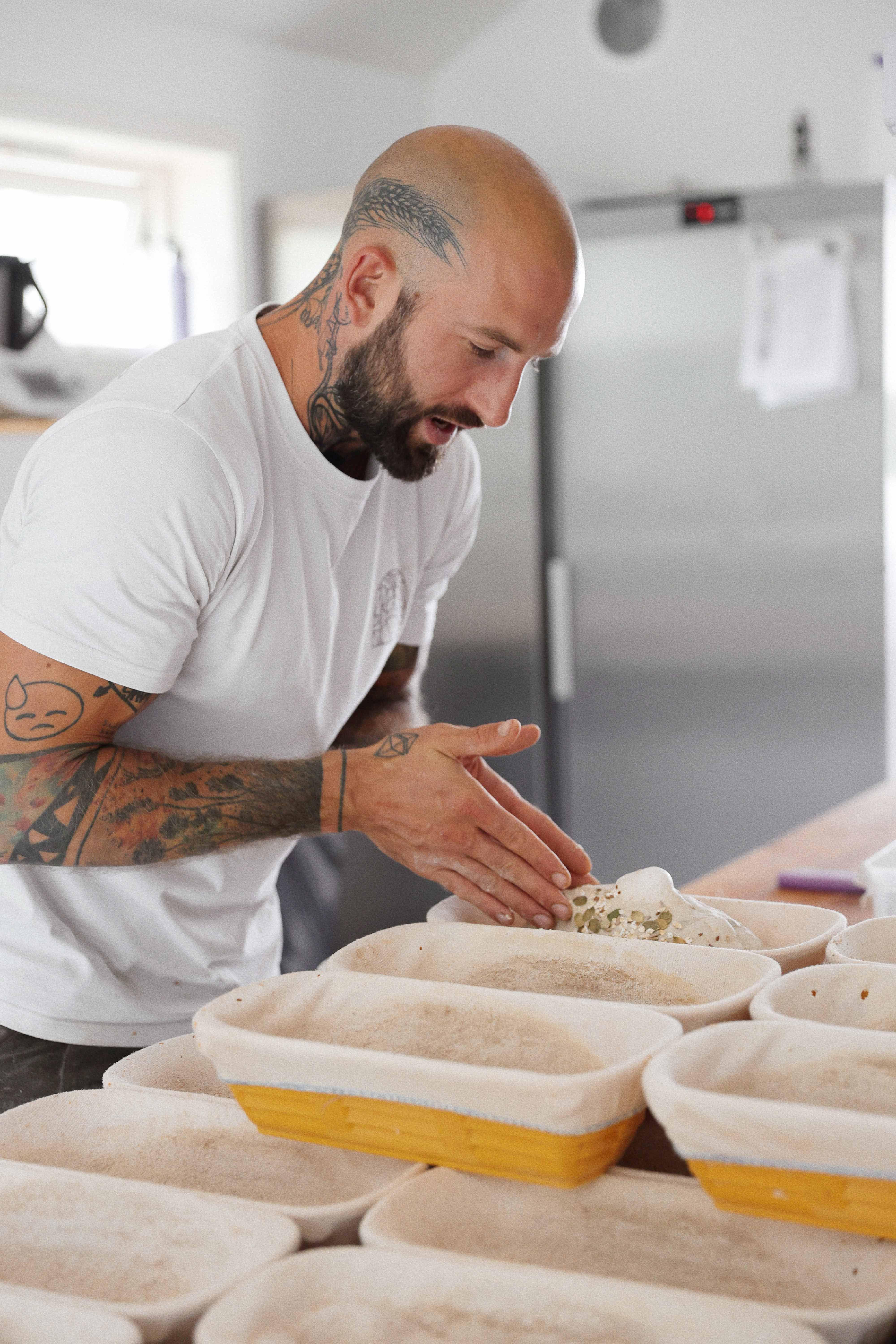 The baker at Vik Restaurant, Bakeri & Kafé shaping dough for fresh baked goods.