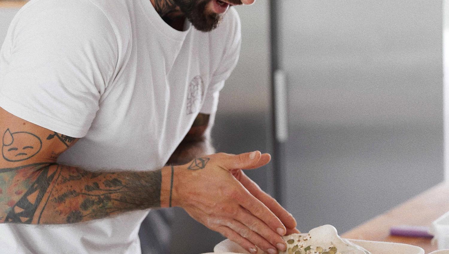 The baker at Vik Restaurant, Bakeri & Kafé shaping dough for fresh baked goods.