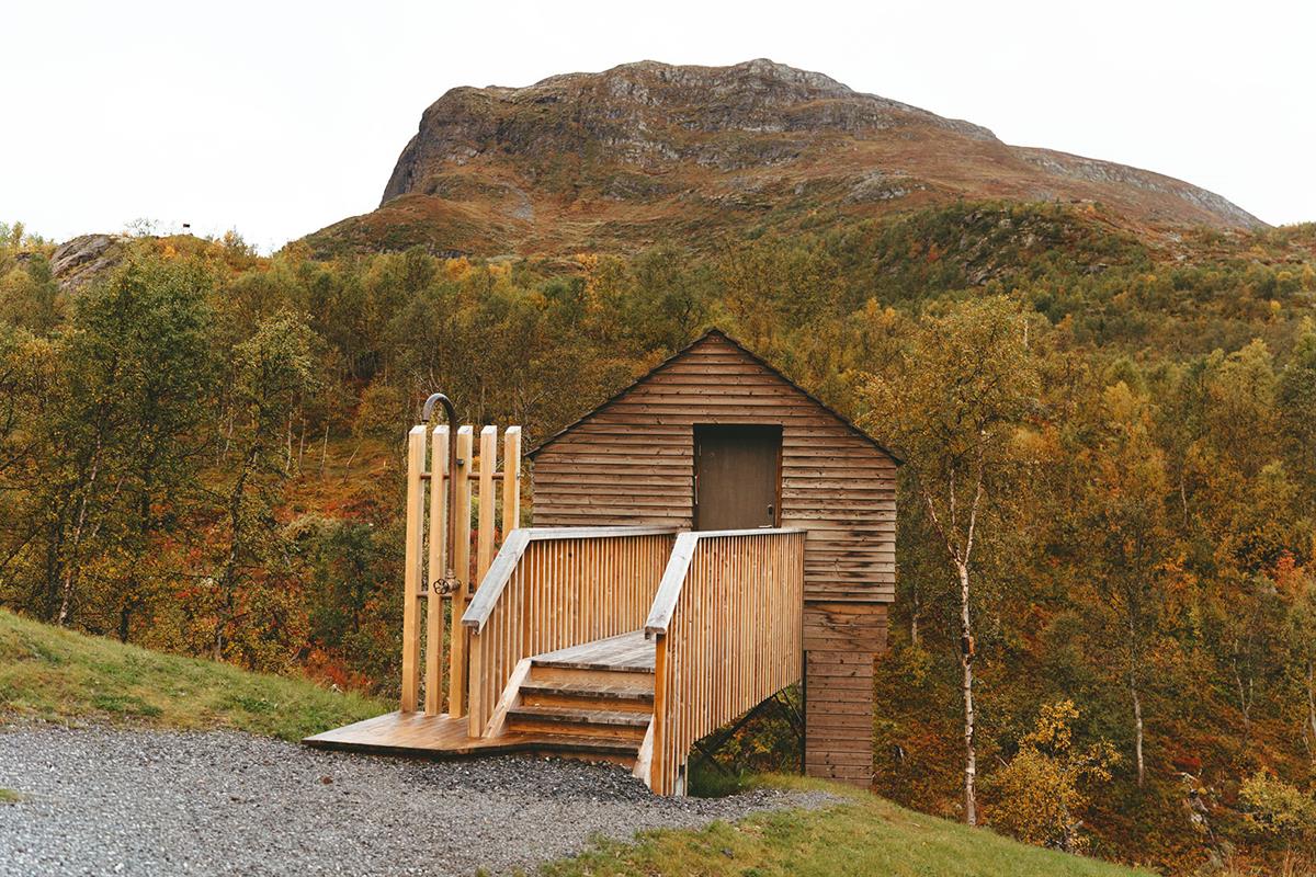 Badstuen på Filefjellstuene. Fjell og skog i bakgrunnen.