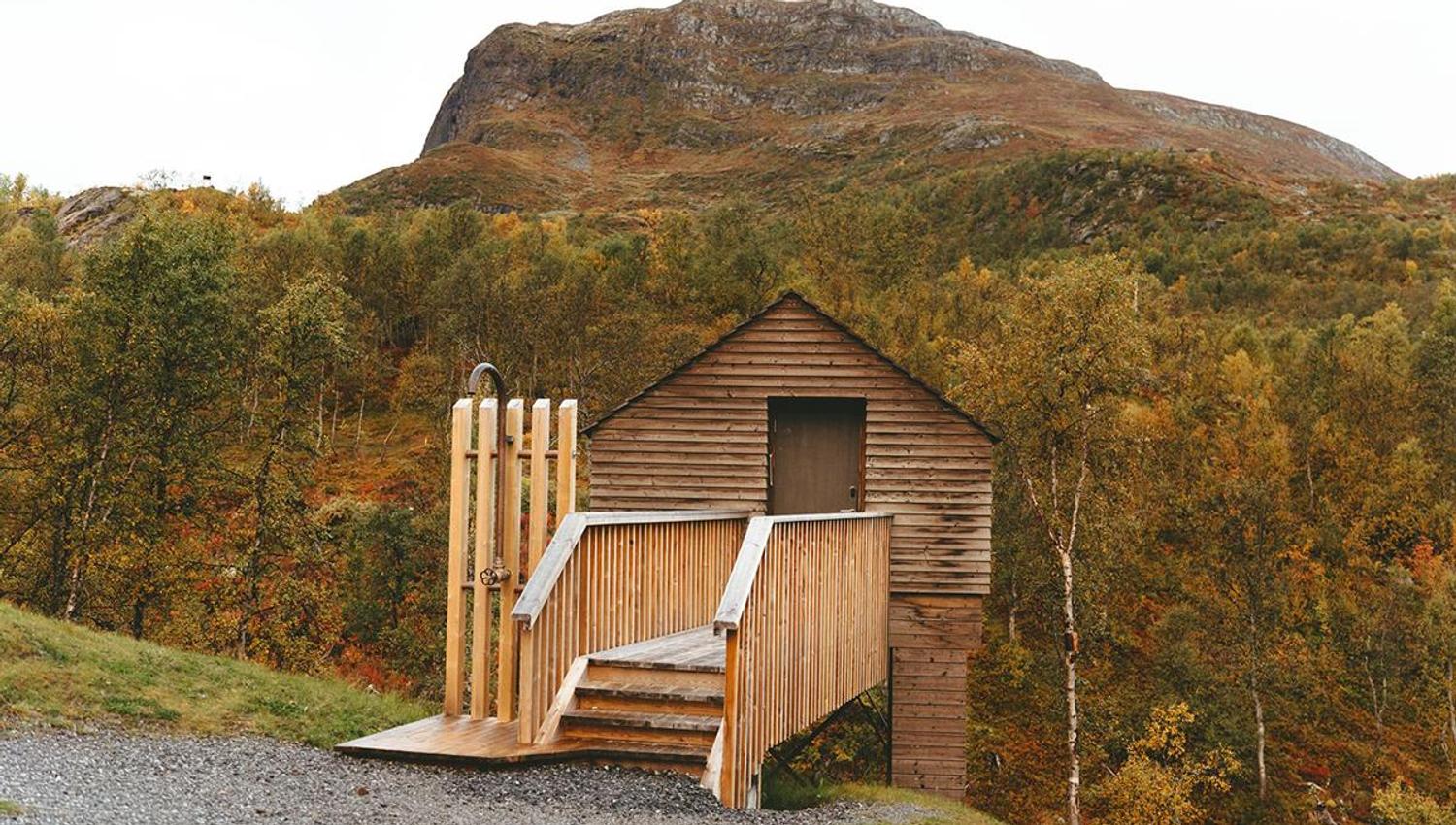 Badstuen på Filefjellstuene. Fjell og skog i bakgrunnen.