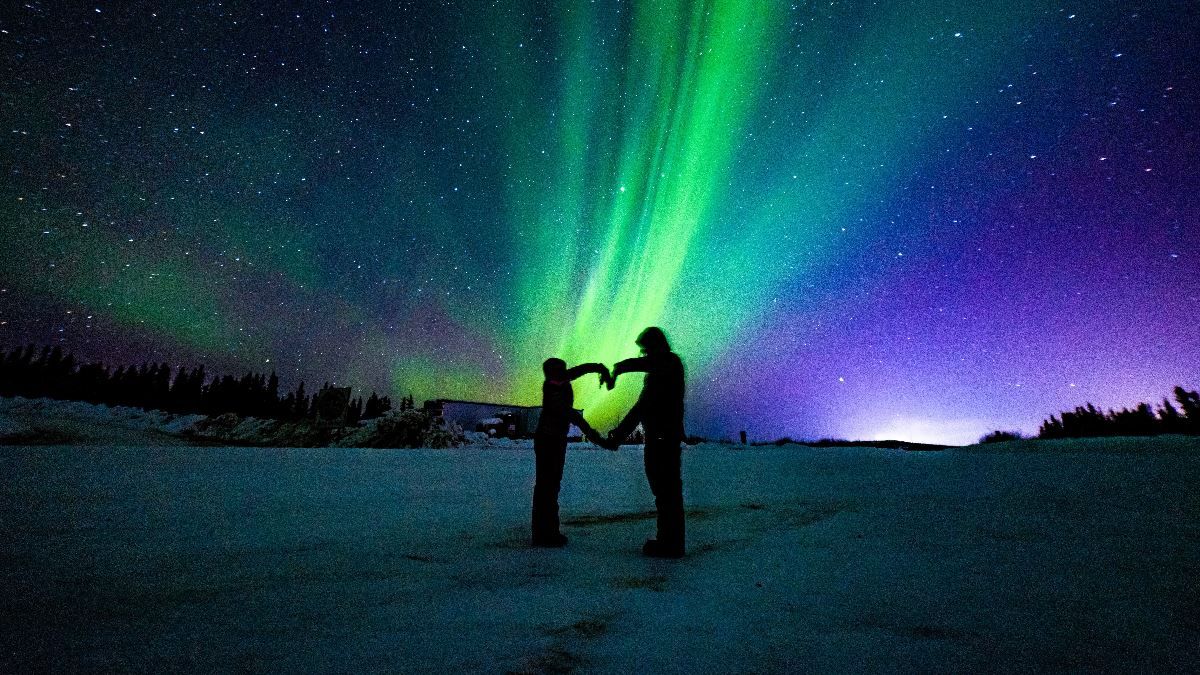 Two people making a heart by using their hands