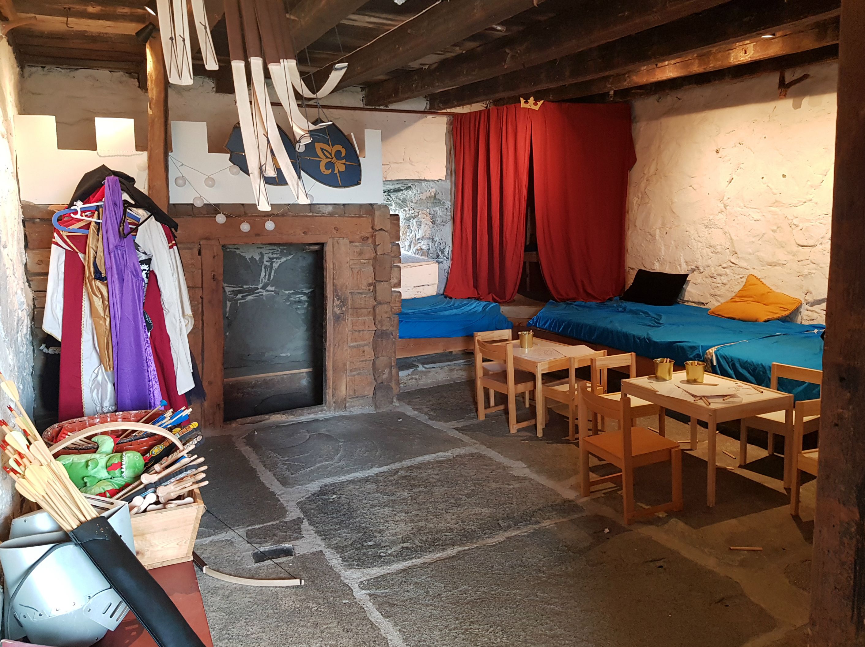 A room with medieval costumes and a seating area. 