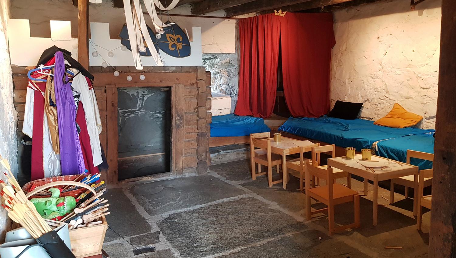 A room with medieval costumes and a seating area.