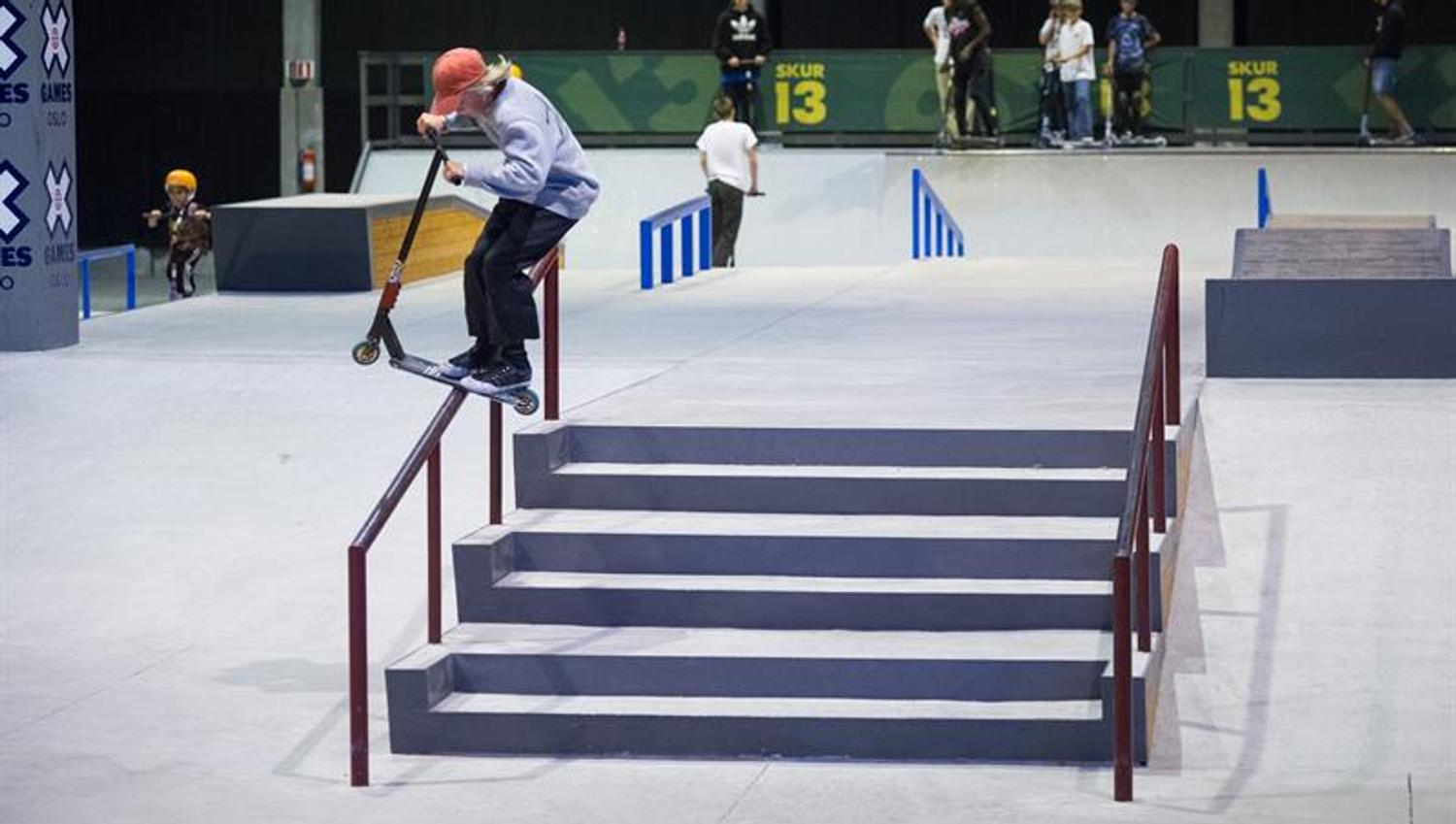 person doing tricks with a scooter on a ramp