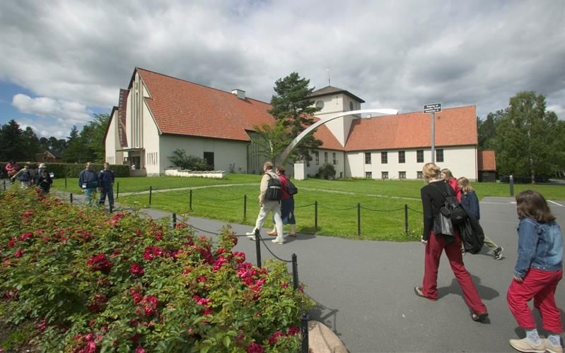 Exterior of the museum, with a lawn and rose bushes in front of it.
