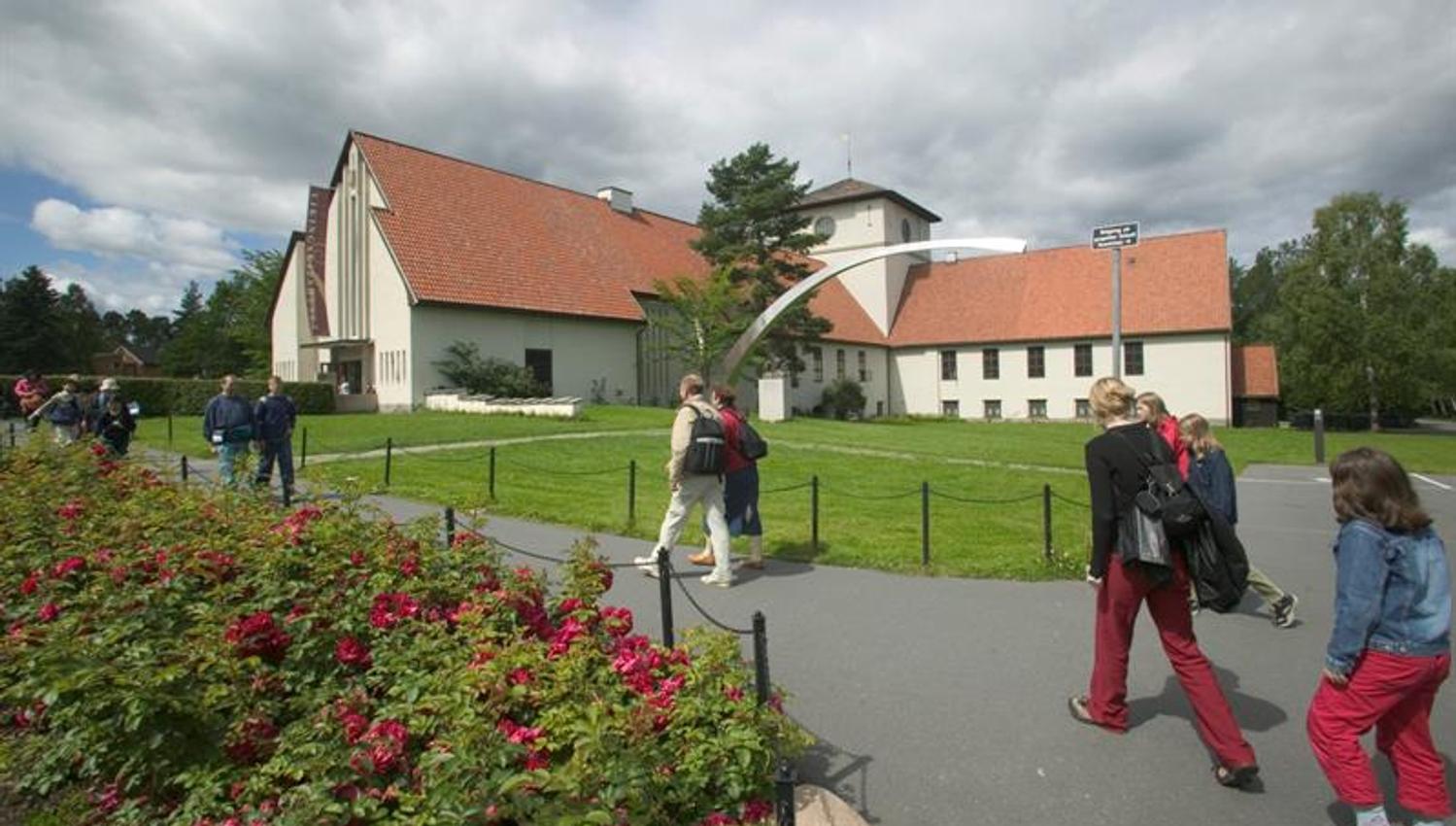 Exterior of the museum, with a lawn and rose bushes in front of it.
