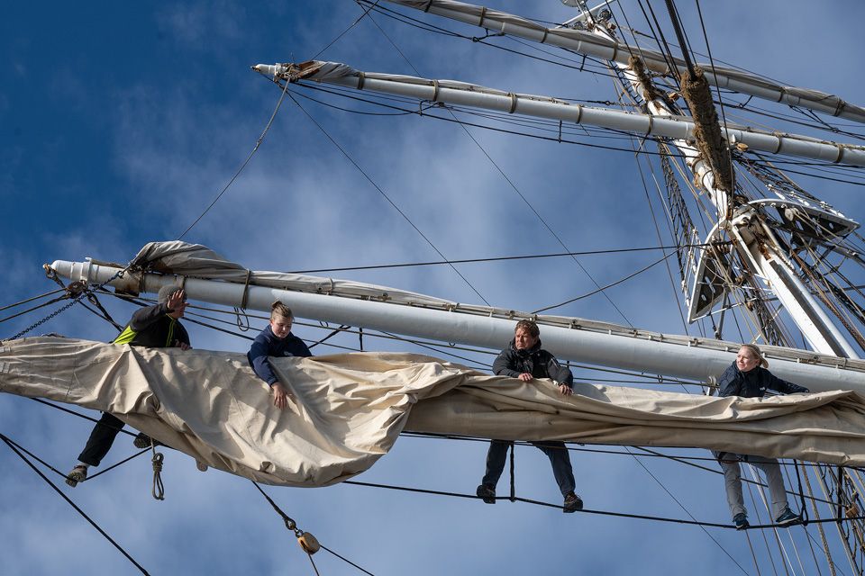 People hanging from the mast.