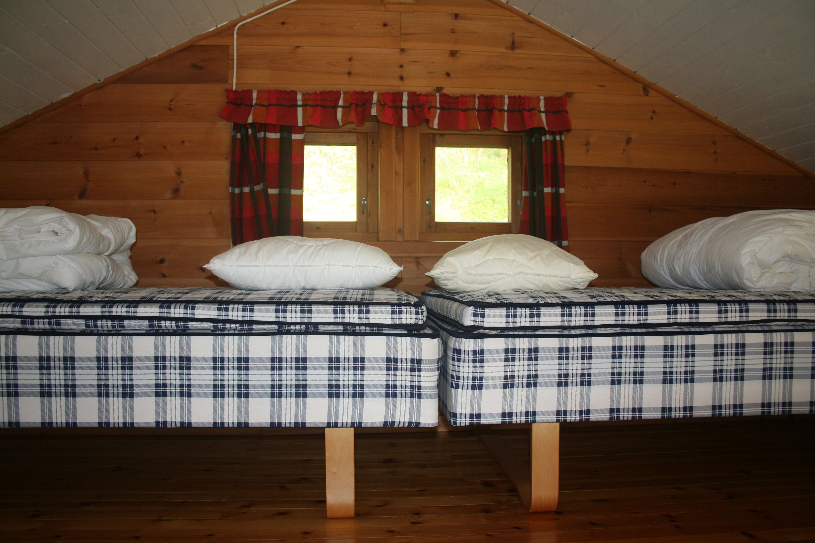 Cozy loft area with two comfortable single beds and a charming window view.