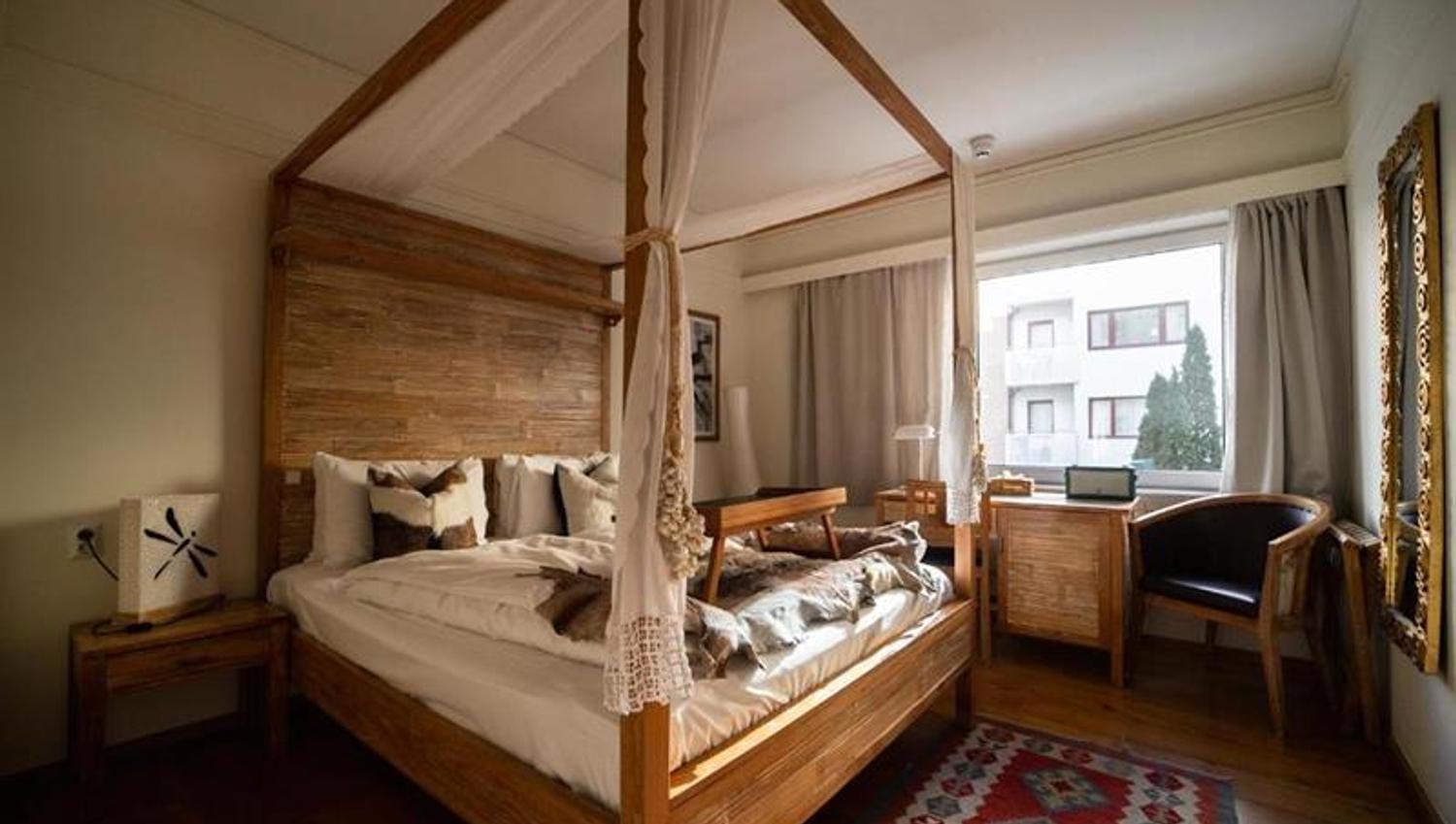 Pleasant double room with handcrafted wooden furniture and a warm, inviting atmosphere – perfect for relaxation.