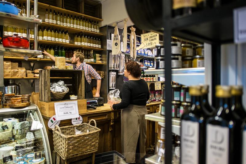 Employee helping a customer with olive oil.