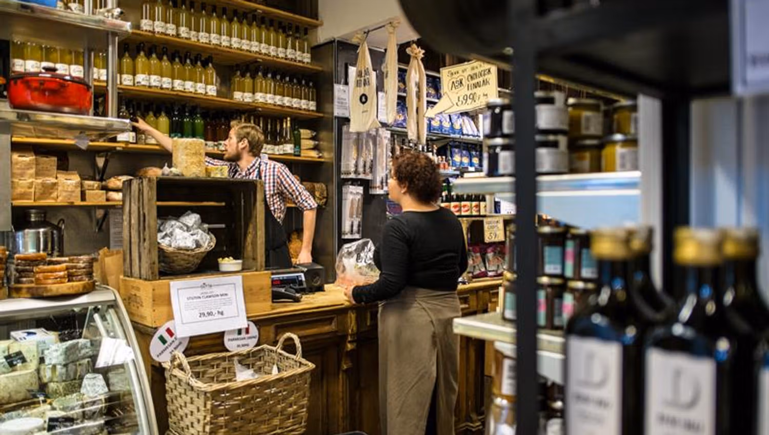 Employee helping a customer with olive oil.