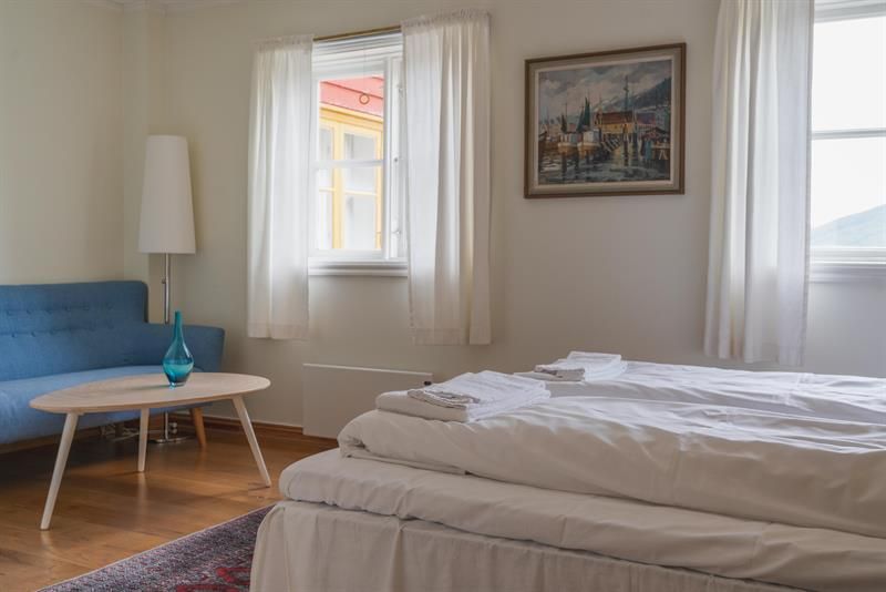 A double room with a blue couch in the corner.
