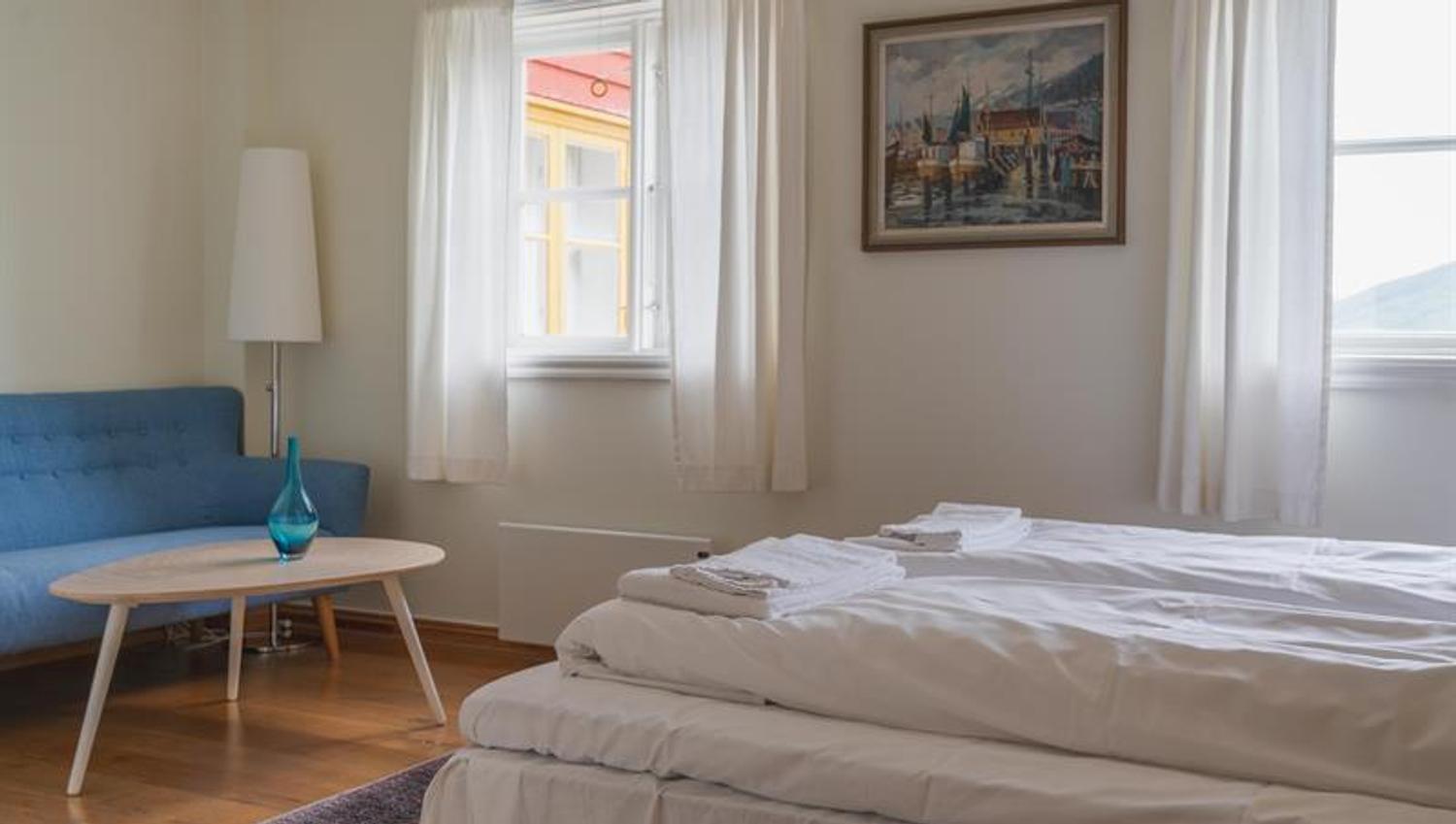 A double room with a blue couch in the corner.