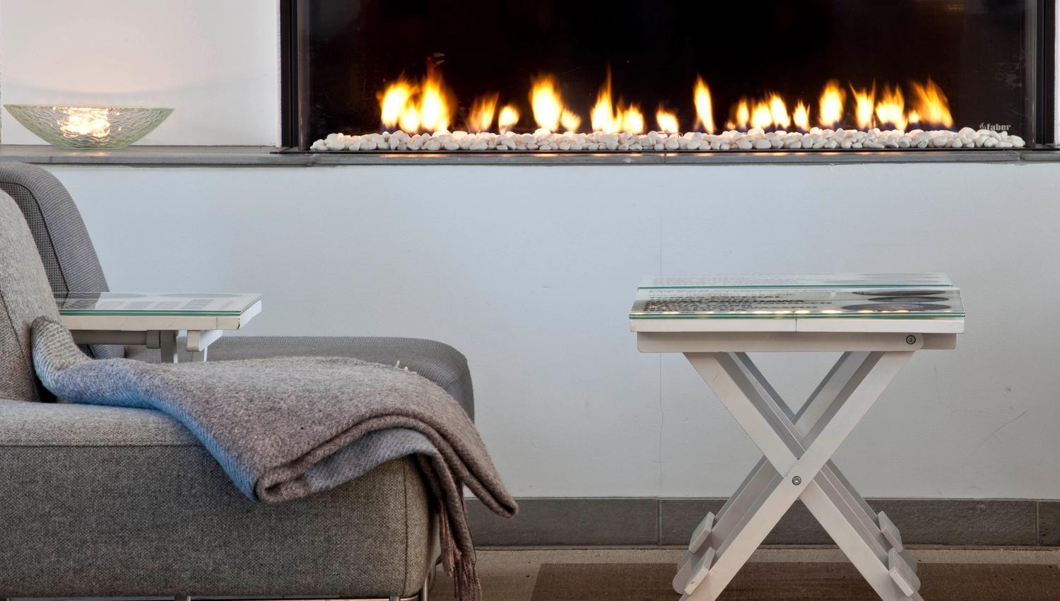 Tables and comfortable chairs in front of the fireplace at Stasjonen Cafe & Restaurant