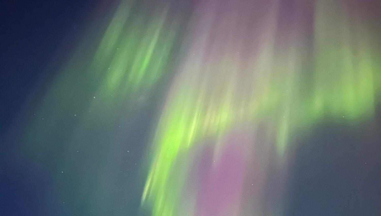 Witness the breathtaking beauty of the Northern Lights as vibrant waves of green and purple illuminate the night sky. This stunning natural phenomenon creates a magical atmosphere, captivating all who gaze upon it.