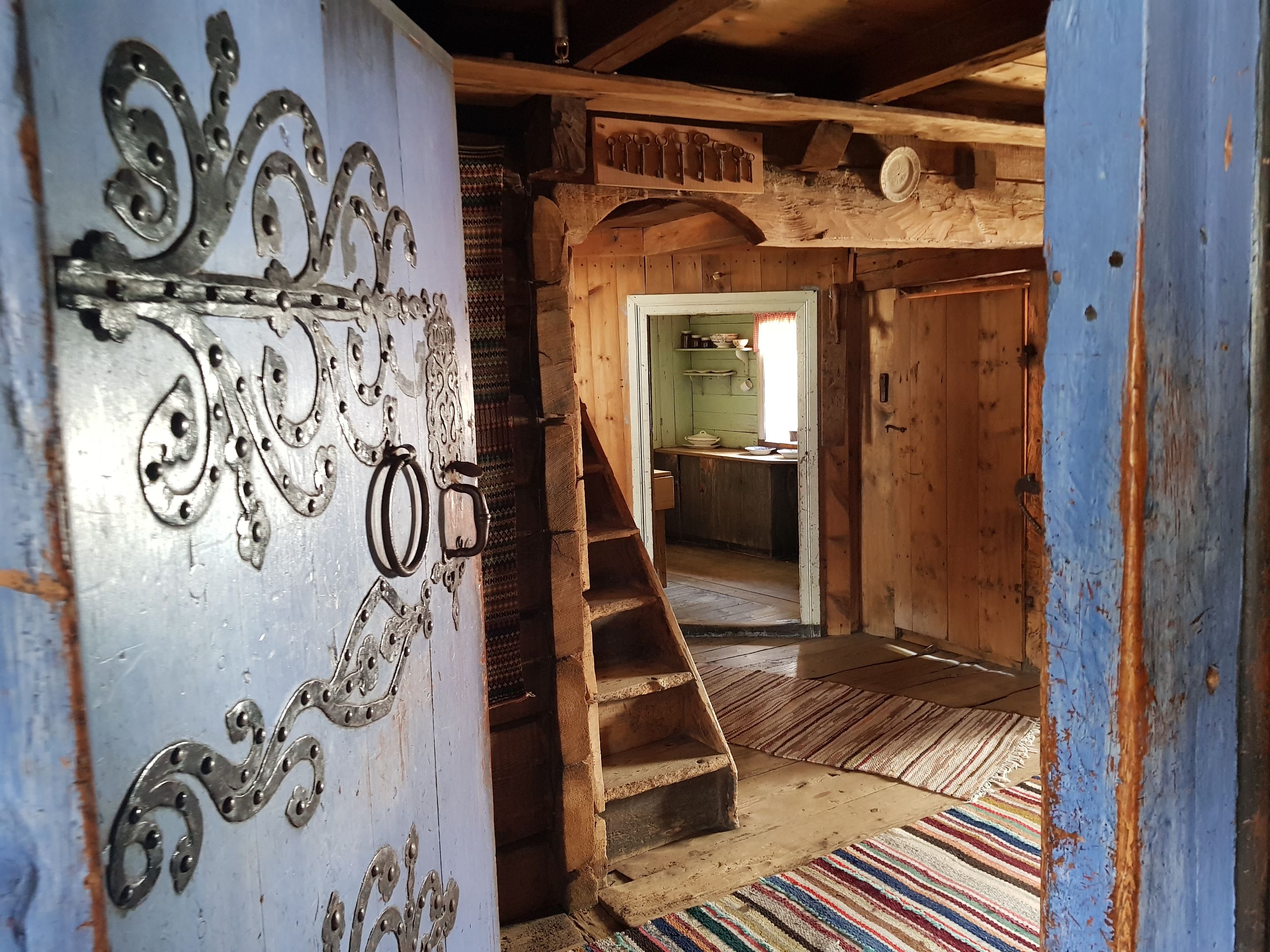 One of the blue doors is open and we can see into a room with a small staircase