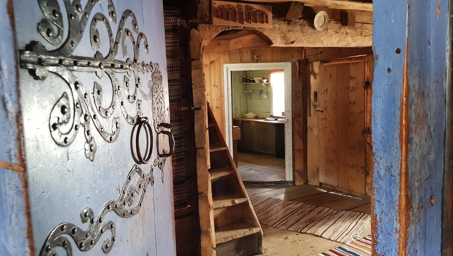 One of the blue doors is open and we can see into a room with a small staircase