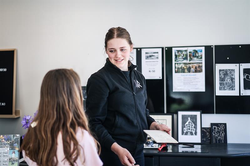 An employee shows woodcuts to a child.
