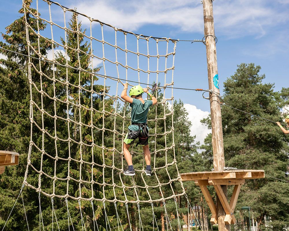gutt klatrer i nett i klatrepark i Skien fritidspark