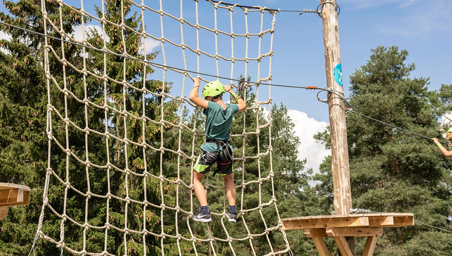 gutt klatrer i nett i klatrepark i Skien fritidspark