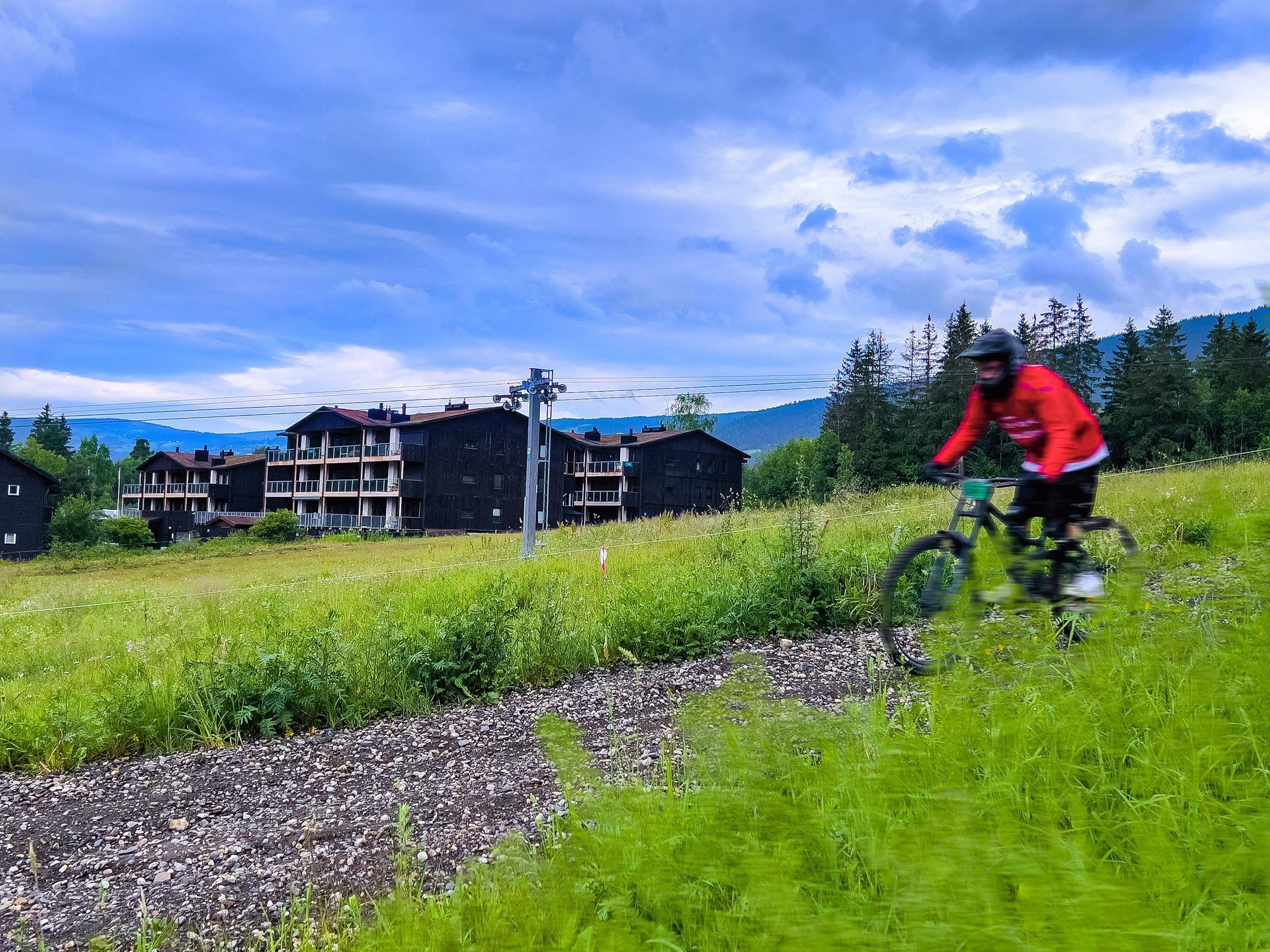 Eine Person, die auf einem Weg im Hafjell Bike Park Fahrrad fährt
