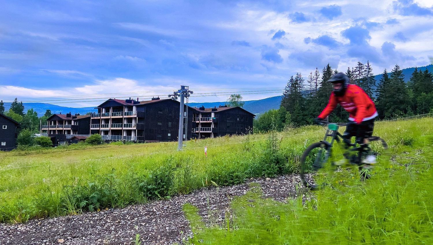 Eine Person, die auf einem Weg im Hafjell Bike Park Fahrrad fährt
