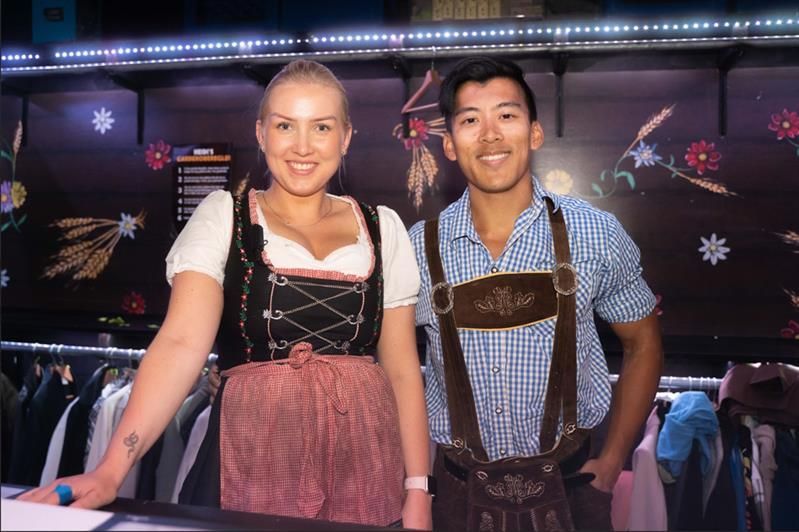 Two employees wearing lederhosen working at the coat check