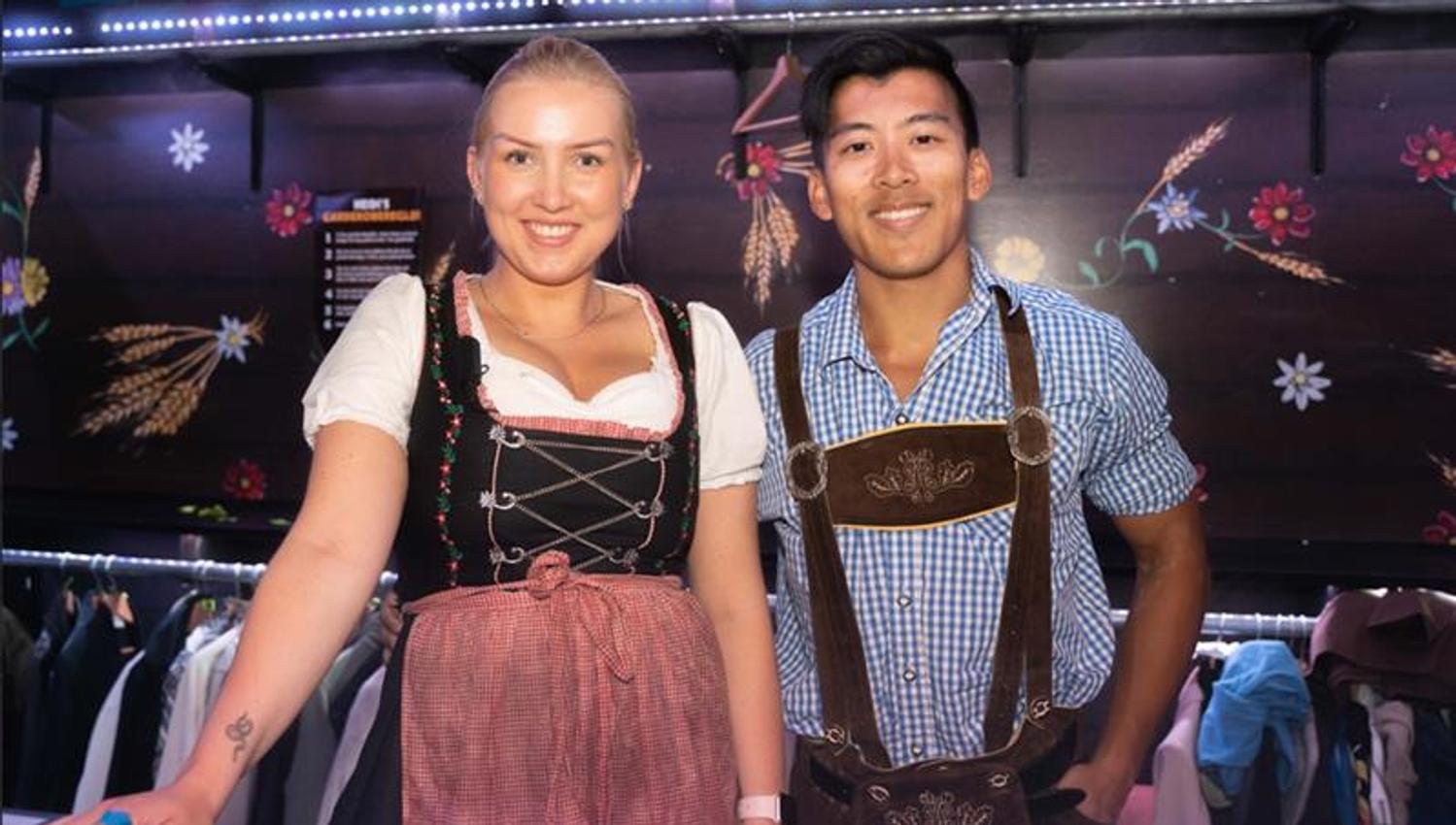 Two employees wearing lederhosen working at the coat check