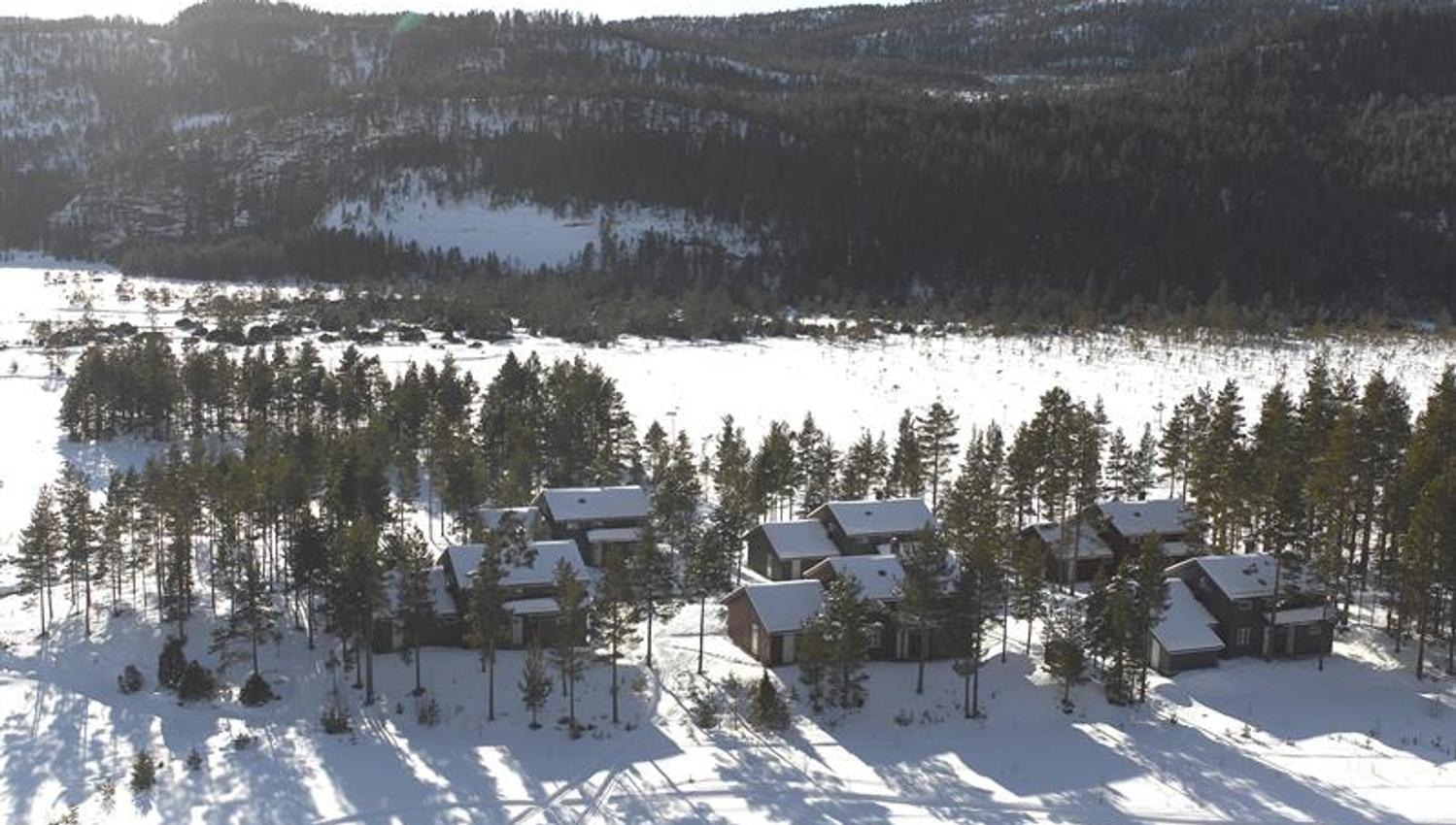Hillestad feriesenter vinterbilde tatt fra lufta med de 6 hyttene og snø på marken.