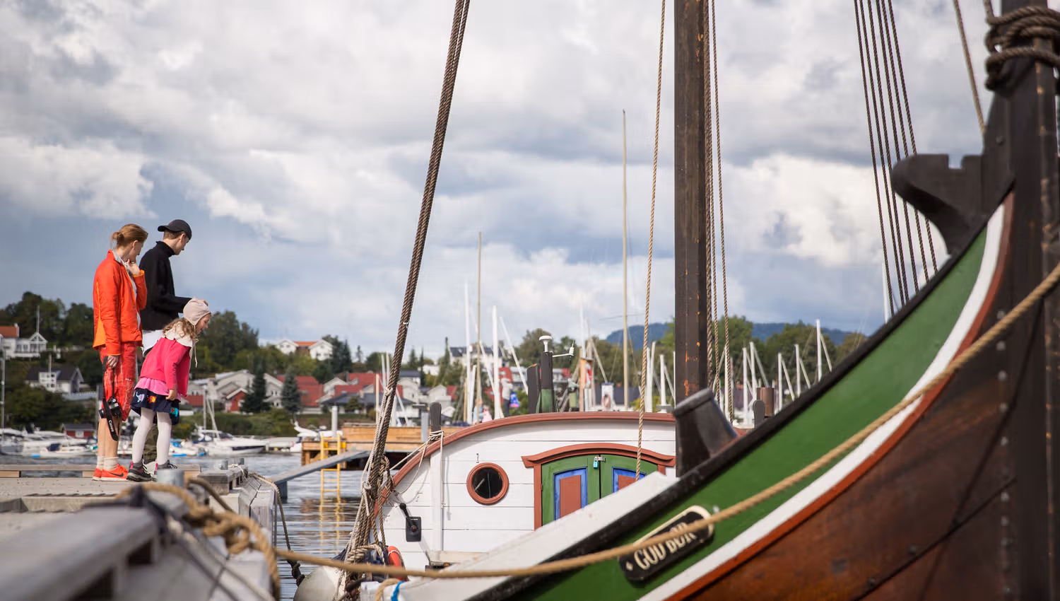 Family on the pier, wooden boat